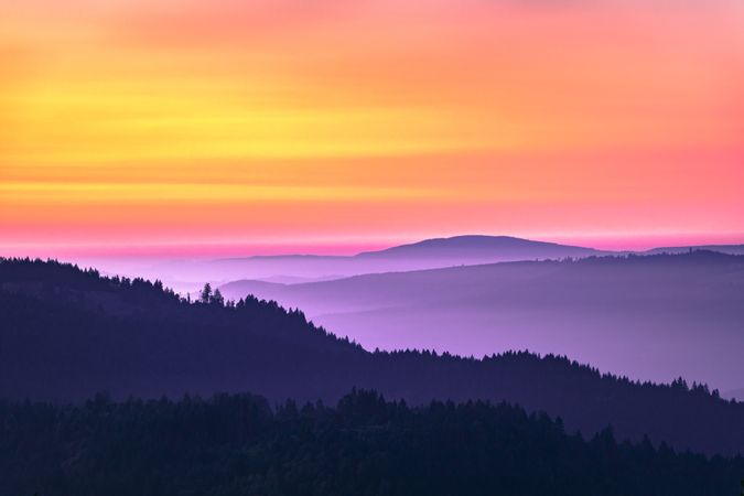 Colorful dusk over tree lined hills on the West Coast