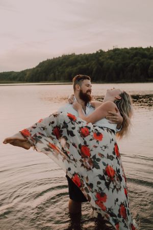 Loving couple standing ankle deep in water on beach