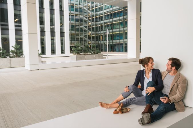 Businesspeople hugging and using smartphone on street