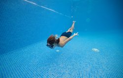 Boy moving in blue swimming pool