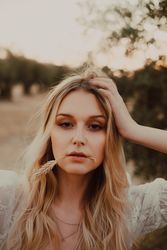 Thoughtful beautiful woman with flowing hair and straw in mouth