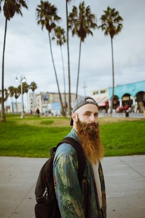 Bearded traveler on pavement in city
