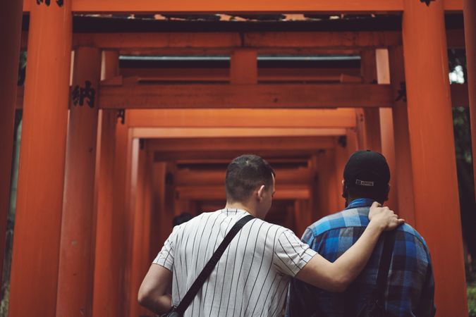 Tokyo, Japan - November 19th, 2019: Two men stand below a torii gate