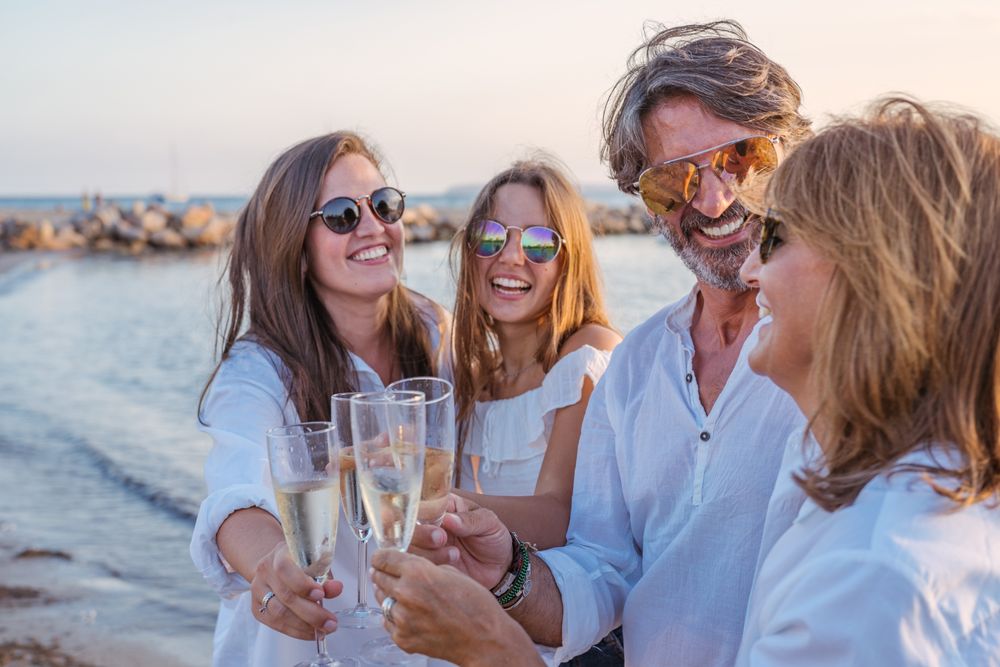 Happy family drinking wine on beach