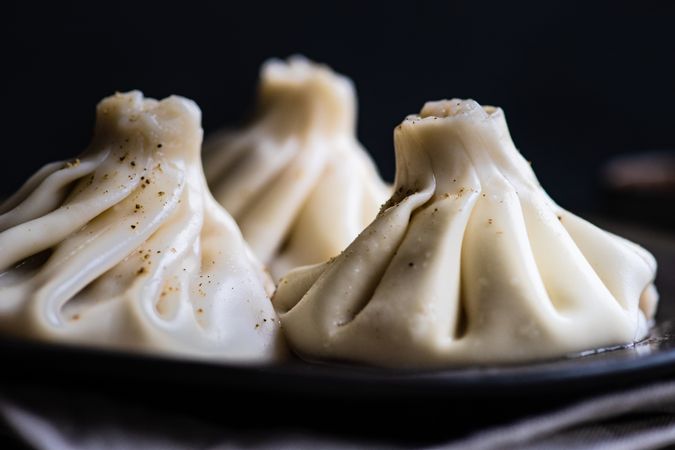 Side view of traditional Georgian khinkali dumplings served on plate