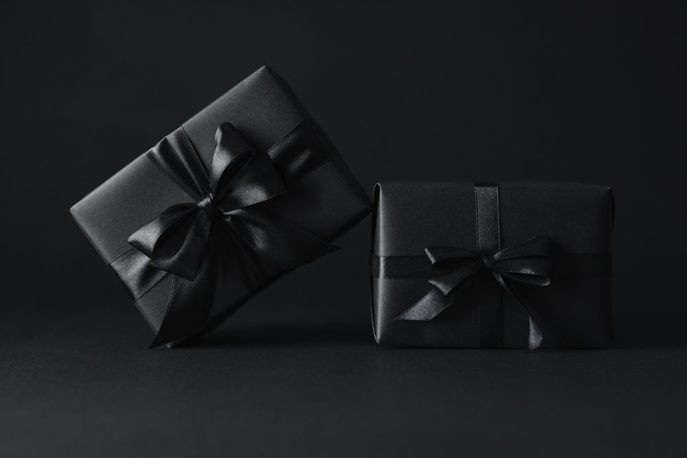 Gift boxes with dark bows on dark background