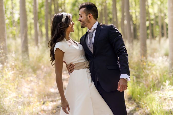 Newlyweds taking photos in a sunny forest