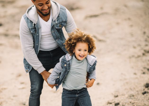 Black father playing with child on ground