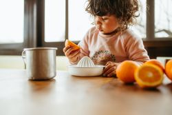 Little girl squeezing oranges