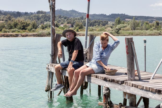 couple sitting on dock dangling with legs