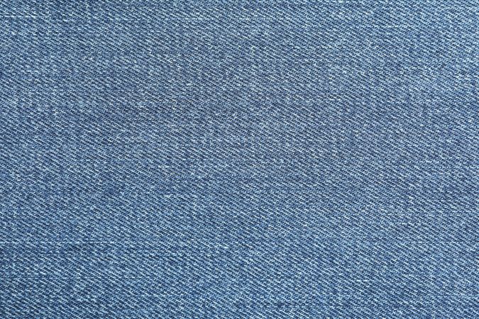 Texture of blue jeans as background, space for text