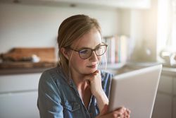 Woman in glasses holding tablet