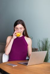 Cheerful woman browsing laptop in living room