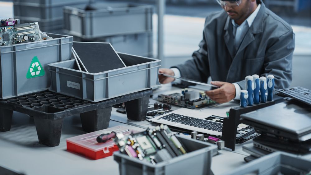 Close Up Shot Of Boxes With Motherboards And Displays From Laptops That Are Being Disassembled By Electronics Factory Workers.