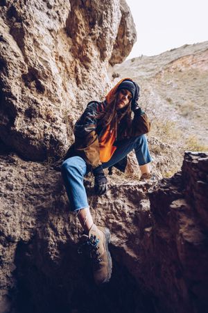 Neutral female hiker resting in rocky slope