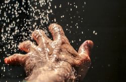 Close-up shot of left human hand with water drops