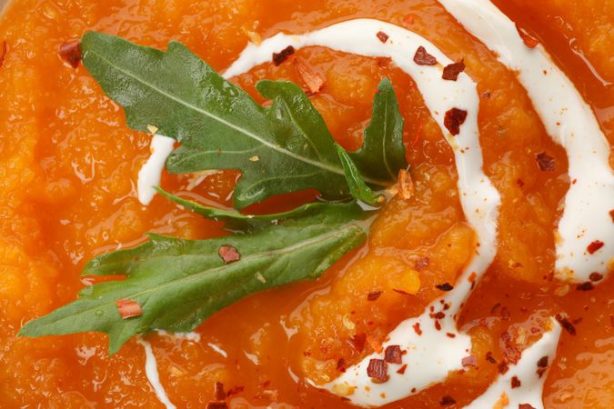 Close up of pumpkin soup with garnish and cream