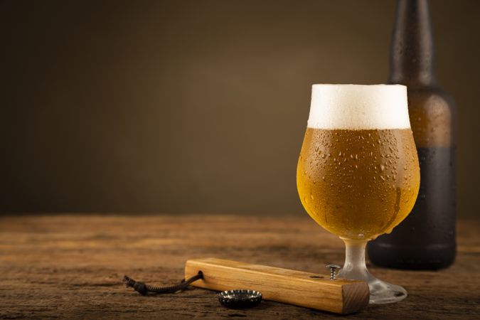 Glass full of cold beer on the wooden table