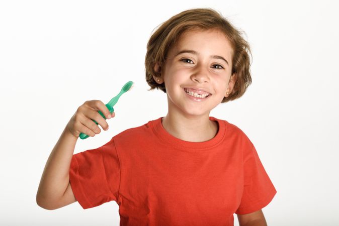 Smiling child brushing her teeth