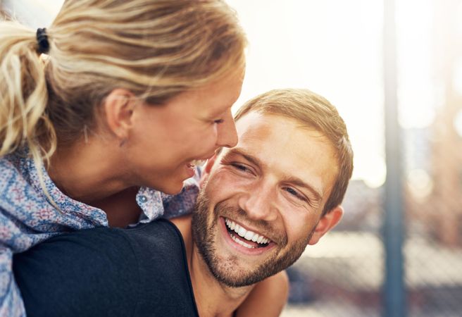 Woman on man’s back, both smiling