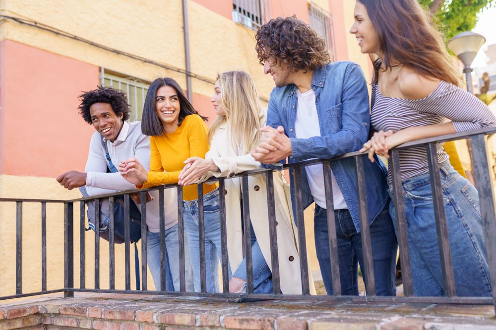 Portrait of happy male and female friends relaxing together outside