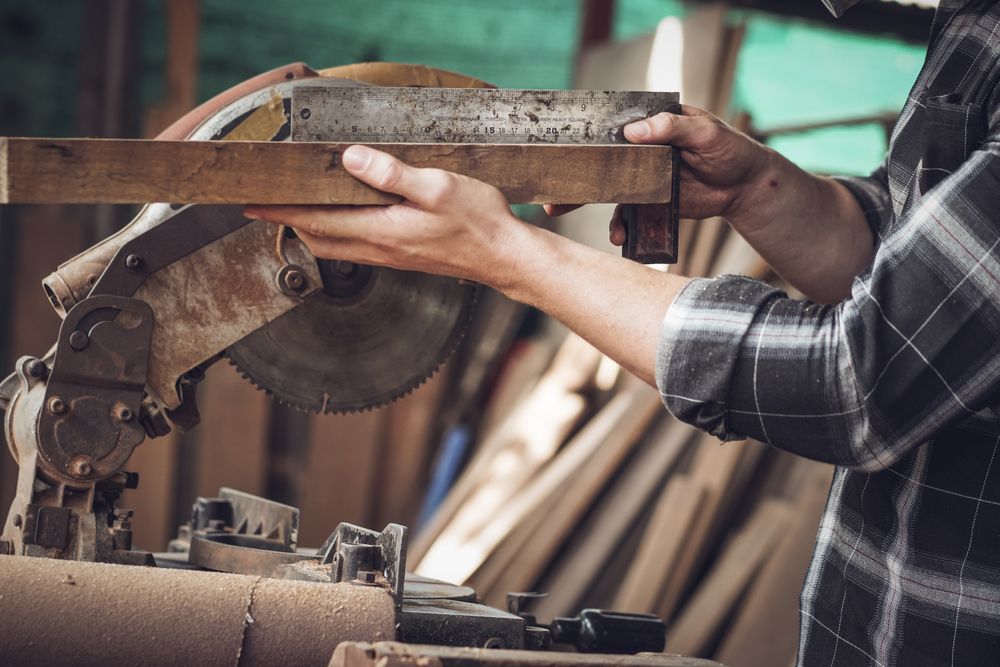 Carpenter hand working on woodworking measuring wood with ruler and pencil