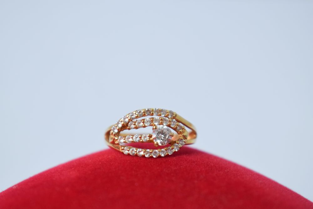 Woman's diamond ring resting on red pillow