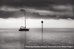 Monochrome image of a single boat sailing bxQwn0