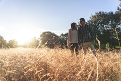 Loving couple walking in golden rural field