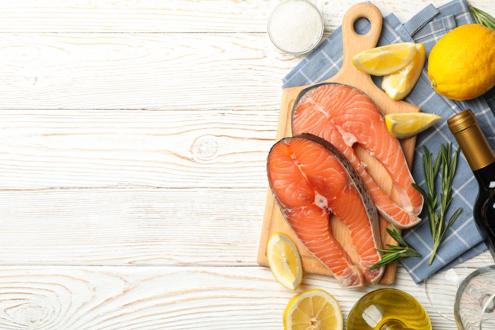 Composition with salmon meat and spices on wooden background, top view