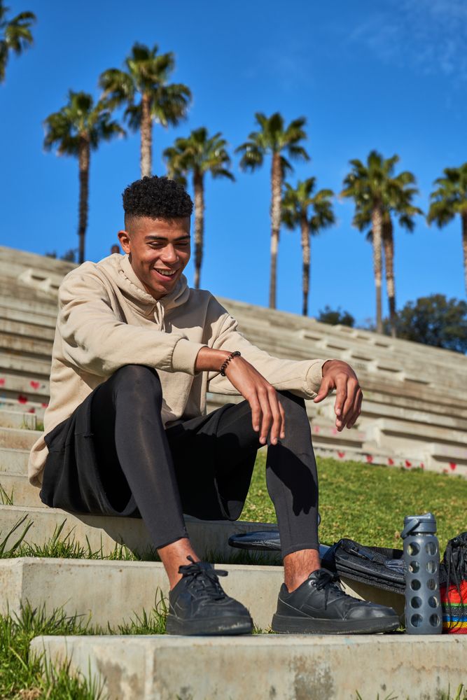 Smiling Hispanic sportsman sitting on stairs