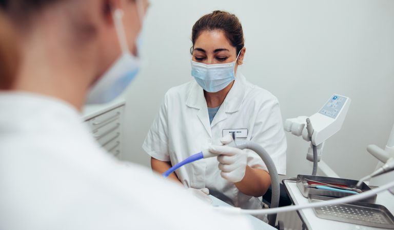 Female assistant working beside doctor in dentist office