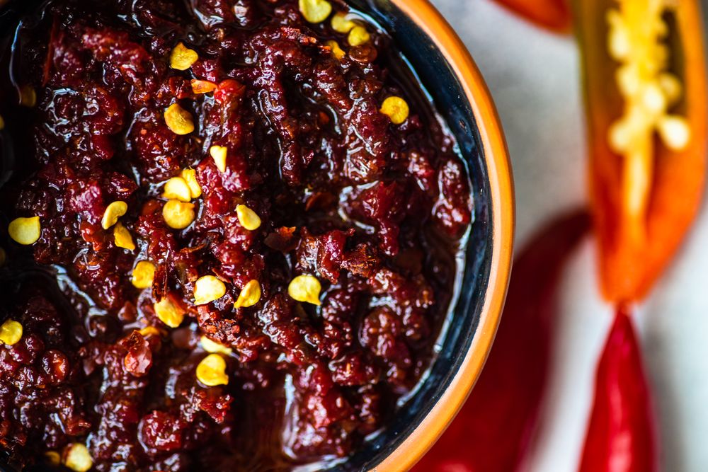 Close up top view of traditional Georgian sauce Adjika with spicy peppers