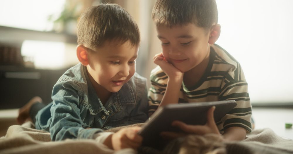 Two Cute Siblings Watching Educational Content Online, Sharing the Gadget, and Enjoying their Time