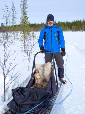 Dog musher with sled