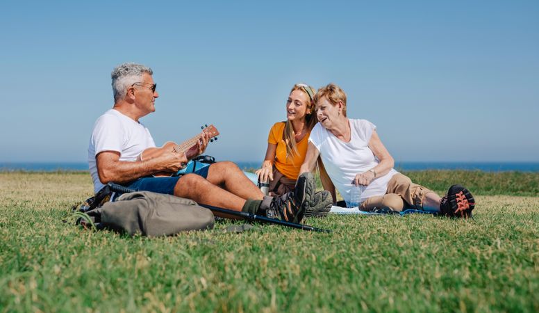 Happy family on outdoor picnic with ukulele