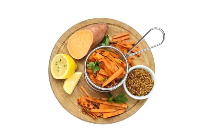fried sweet potato in friture on a board, isolated on light background