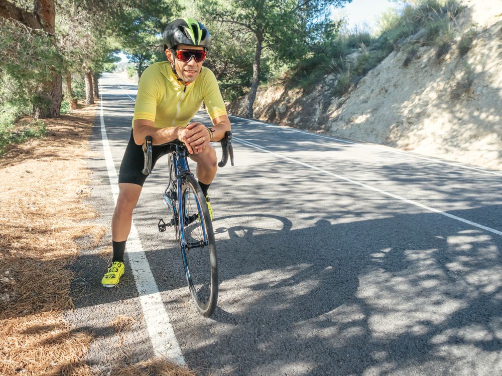 man resting and enjoying the views while riding a bicycle on a mountain road