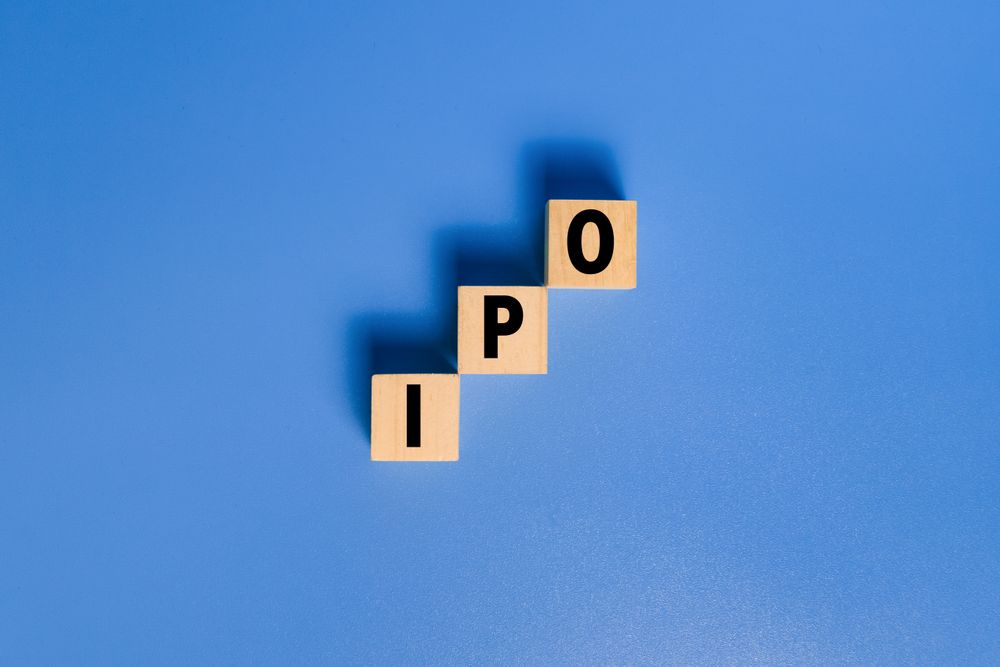 IPO letter text or initial public offering words on wooden blocks isolated on blue background copy space