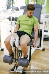 Male in green t-shirt working out on leg machine 0yv1O5