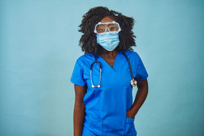 Black female medical professional wearing a face mask, protective eyewear and stethoscope
