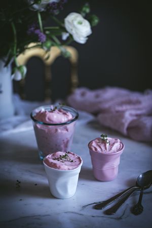 tasty glasses of strawberry mousse on a table with flowers
