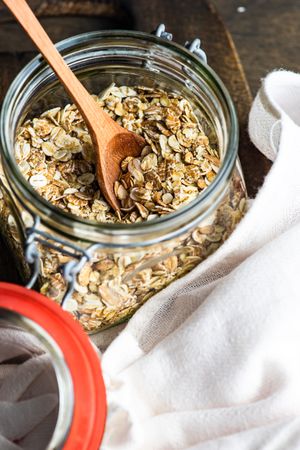 Jar of dry oats with wooden spoon