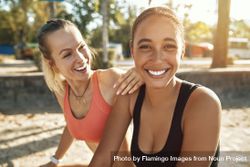 Two young women smiling together outside after a workout 5k1rDb