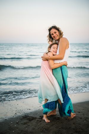 Beautiful mother and daughter embracing on beach