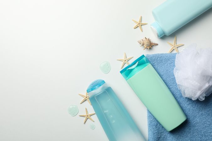 Composition with blank cosmetic bottles and starfishes on light background
