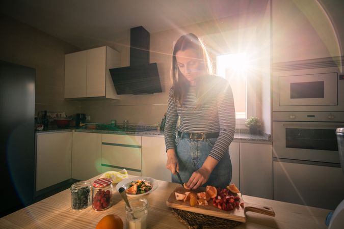 Woman cutting fruits in kitchen