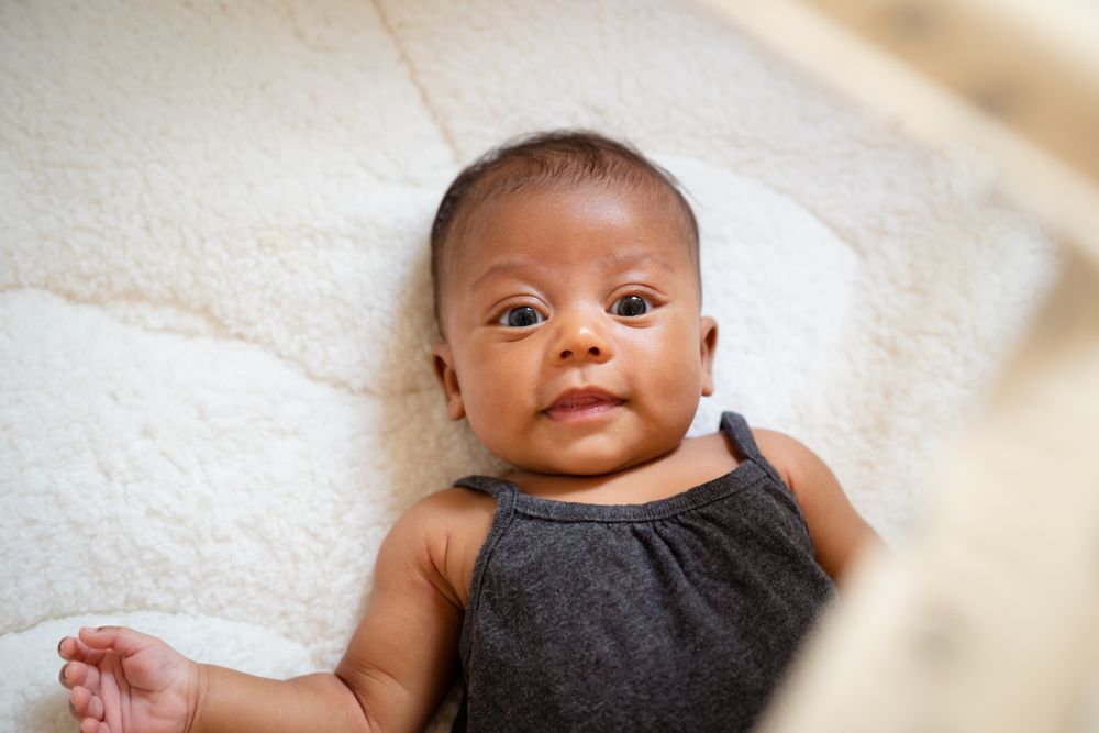 Cute biracial baby girl lying on her back
