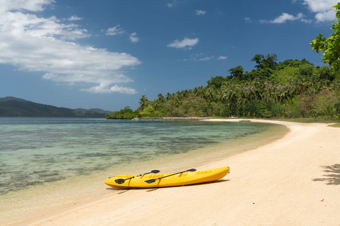 Kayak on sandy beach of tropical shore