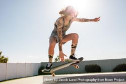 Female skater practicing skateboarding at skate park 4dzNQ0
